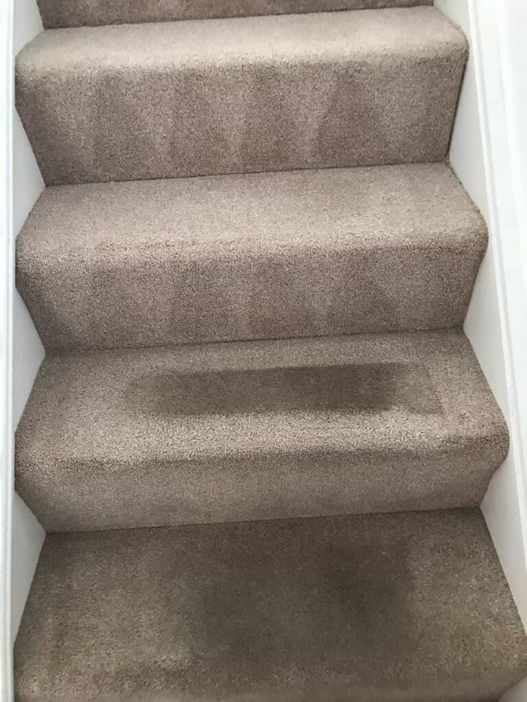 This is a photo of a brown staircase carpet that is being steam cleaned by K&S Carpet Cleaning